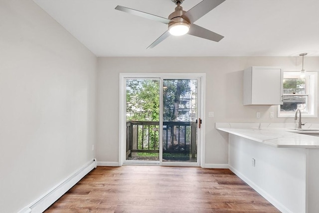2 Howe Ter Unit 11, Boston, MA 02125 - unfurnished dining area with baseboard heating, light wood-type flooring, and baseboards