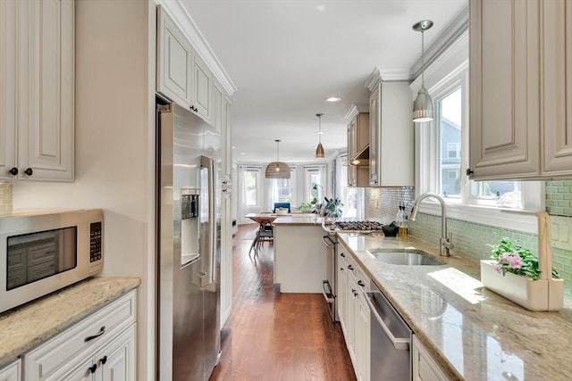 42 Sylvia Rd Unit 42, Medford, MA 02155 - kitchen featuring appliances with stainless steel finishes, a sink, dark wood finished floors, backsplash, and light stone countertops