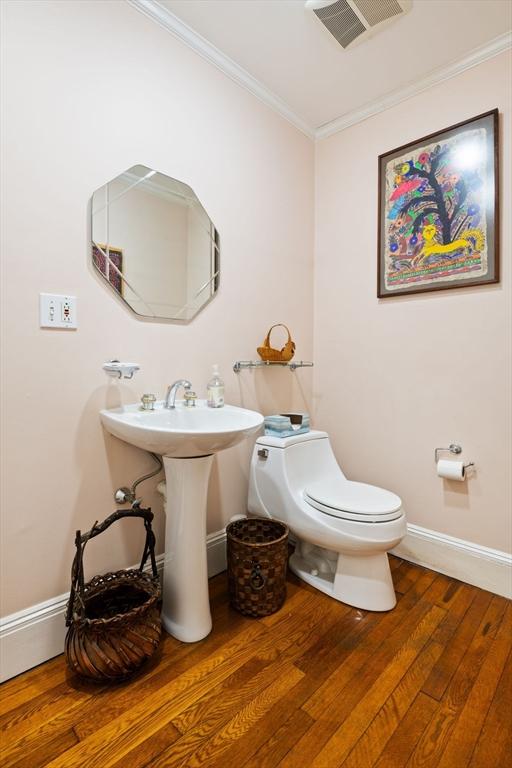46 Central Ave, Newton, MA 02460 - bathroom featuring crown molding, toilet, baseboards, visible vents, and hardwood / wood-style floors
