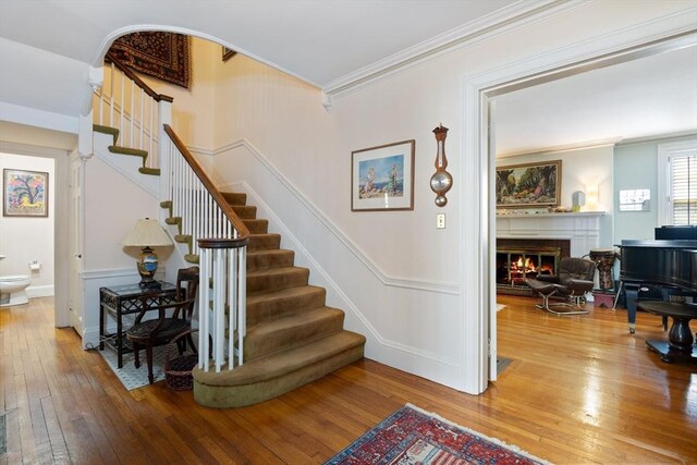 46 Central Ave, Newton, MA 02460 - stairway with ornamental molding, a glass covered fireplace, and wood-type flooring