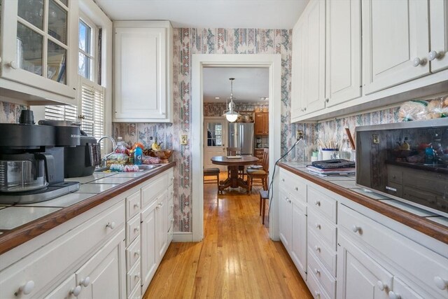 46 Central Ave, Newton, MA 02460 - kitchen featuring tile countertops, wallpapered walls, and white cabinetry