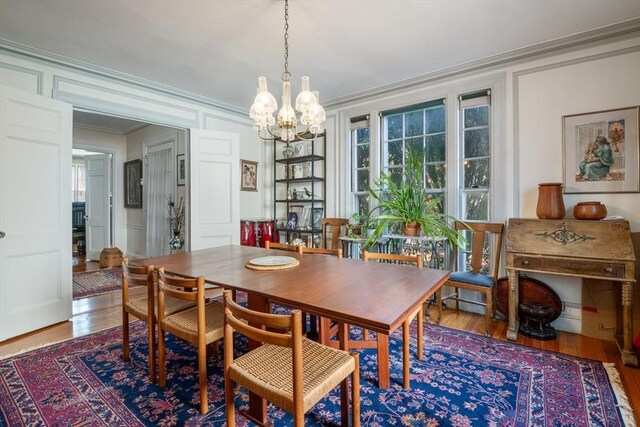 46 Central Ave, Newton, MA 02460 - dining area featuring crown molding, wood finished floors, a decorative wall, and a chandelier