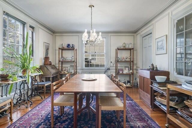 46 Central Ave, Newton, MA 02460 - dining area with a notable chandelier, wood finished floors, a decorative wall, and crown molding