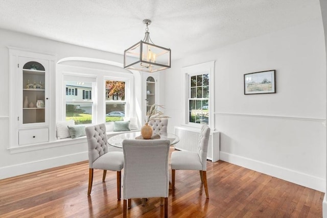 28 Saltonstall Rd, North Andover, MA 01845 - dining space featuring a chandelier, baseboards, wood finished floors, and a textured ceiling