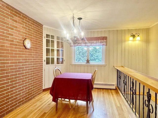 dining room featuring brick wall, ornamental molding, baseboard heating, and wood finished floors