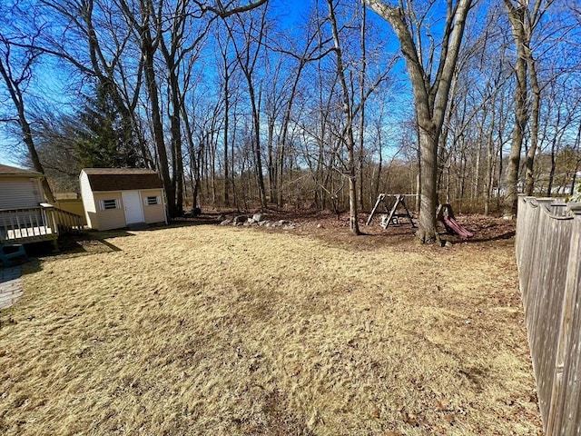 view of yard featuring a shed, a wooden deck, and an outbuilding