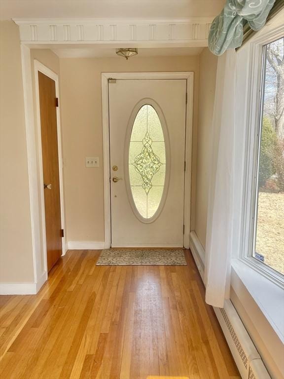 foyer featuring light wood-style flooring and baseboards