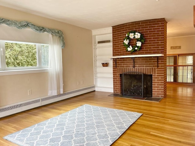 unfurnished living room featuring built in features, a fireplace, a baseboard heating unit, and wood finished floors