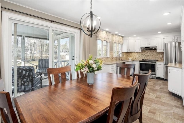 dining area with recessed lighting, crown molding, and an inviting chandelier