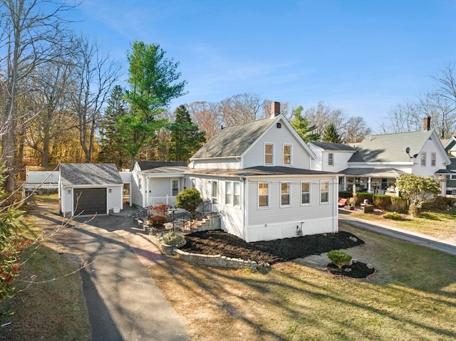 view of front of property with a garage, an outbuilding, and a front yard