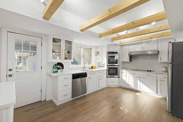 kitchen featuring backsplash, white cabinets, sink, light wood-type flooring, and appliances with stainless steel finishes