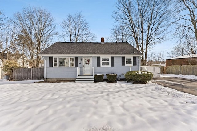 view of front of property with roof with shingles, fence, and a chimney