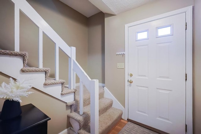 entryway with a textured ceiling and hardwood / wood-style flooring