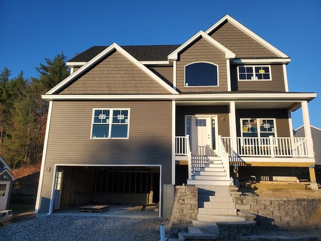 craftsman-style home featuring a garage, covered porch, and driveway