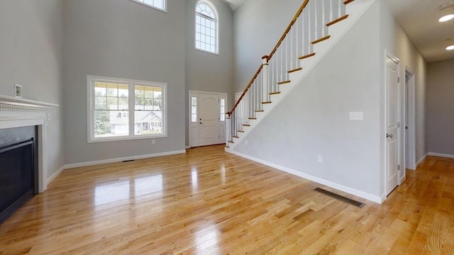 3 Mulligan Unit 3, Kingston, NH 03848 - foyer entrance with stairway, light wood finished floors, a fireplace, and a high ceiling