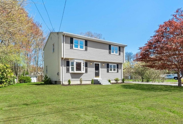 colonial home featuring a front lawn