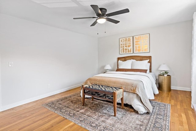 bedroom featuring baseboards, ceiling fan, and light wood-style flooring