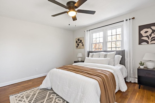 bedroom with baseboards, ceiling fan, baseboard heating, and wood finished floors
