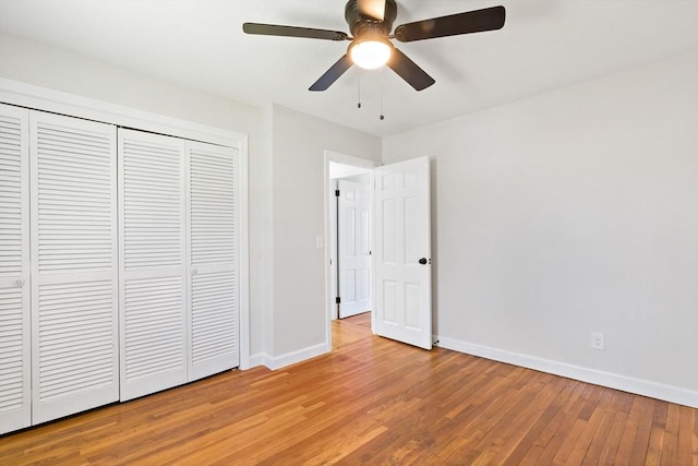 unfurnished bedroom with light wood-style floors, baseboards, a ceiling fan, and a closet