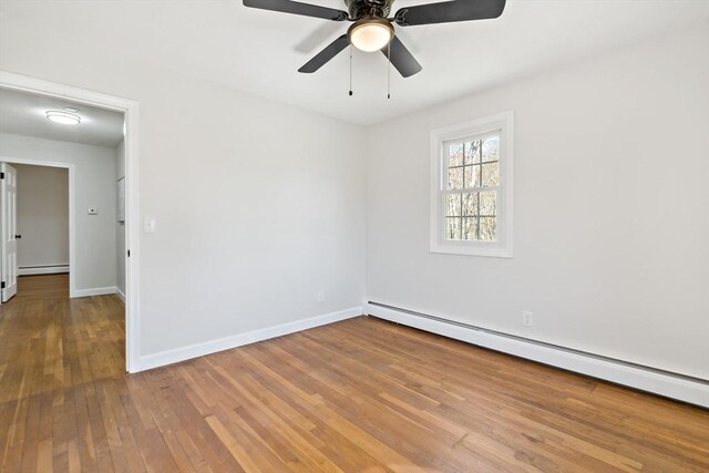 unfurnished room with ceiling fan, baseboards, a baseboard radiator, a baseboard heating unit, and hardwood / wood-style flooring