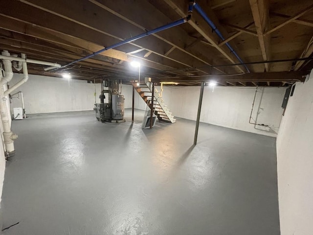 unfinished basement featuring a heating unit, stairs, and water heater