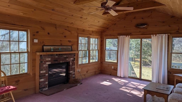 living area with plenty of natural light, wood walls, a fireplace, and lofted ceiling