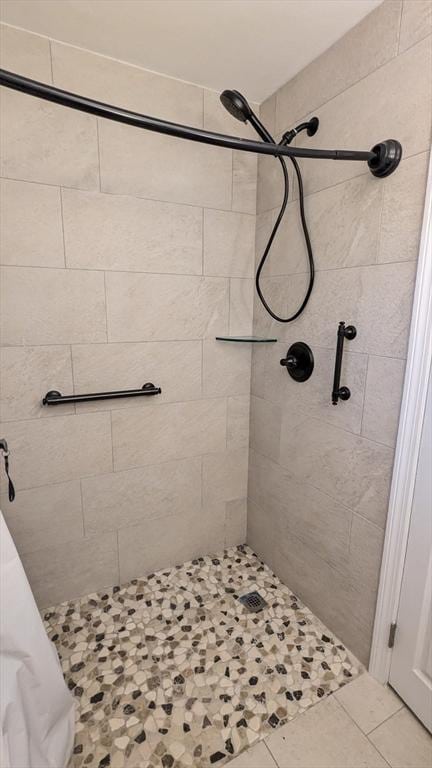 bathroom with tile patterned flooring and a shower stall