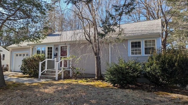 ranch-style home featuring driveway, roof with shingles, a chimney, and an attached garage