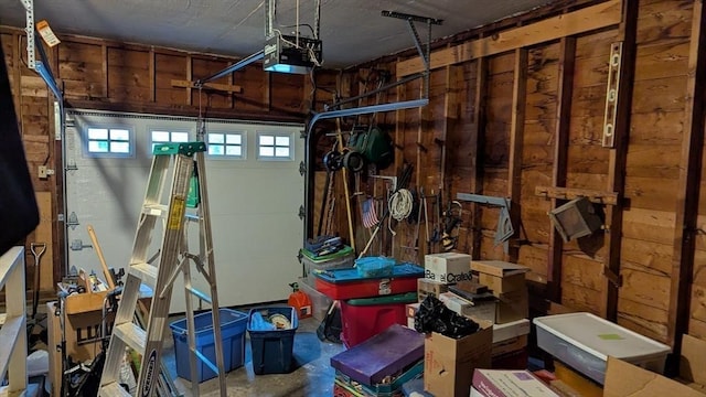 garage featuring wooden walls and a garage door opener