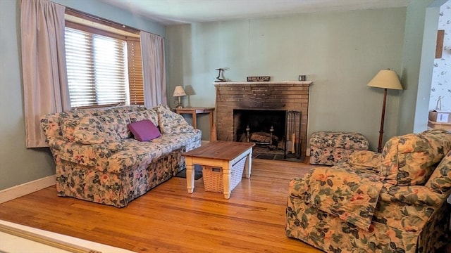 living room featuring baseboards, wood finished floors, and a fireplace