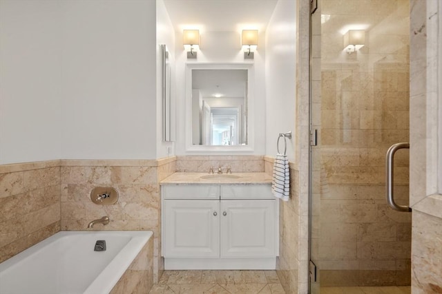 bathroom featuring a garden tub, vanity, and a stall shower