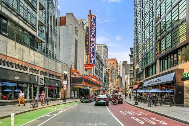view of street featuring sidewalks, a view of city, and street lights