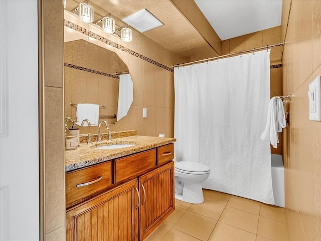 bathroom with tile walls, toilet, shower / bath combo, vanity, and tile patterned floors