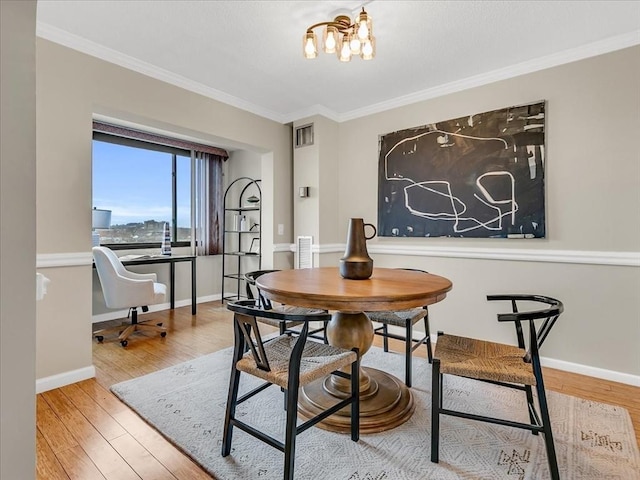 dining room featuring visible vents, crown molding, and wood finished floors