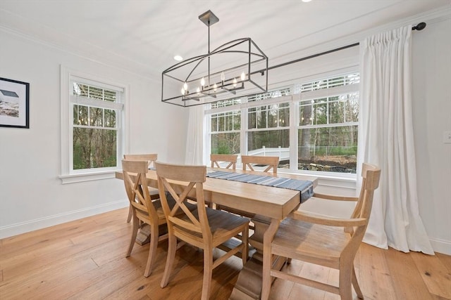 dining space featuring baseboards, a notable chandelier, ornamental molding, recessed lighting, and light wood-style flooring