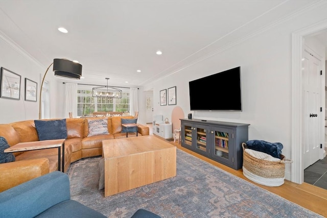 living room featuring crown molding, recessed lighting, wood finished floors, and an inviting chandelier