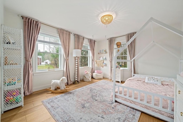 bedroom featuring light wood-type flooring and baseboards