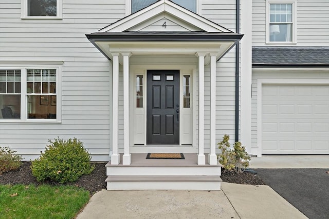 entrance to property featuring an attached garage and driveway