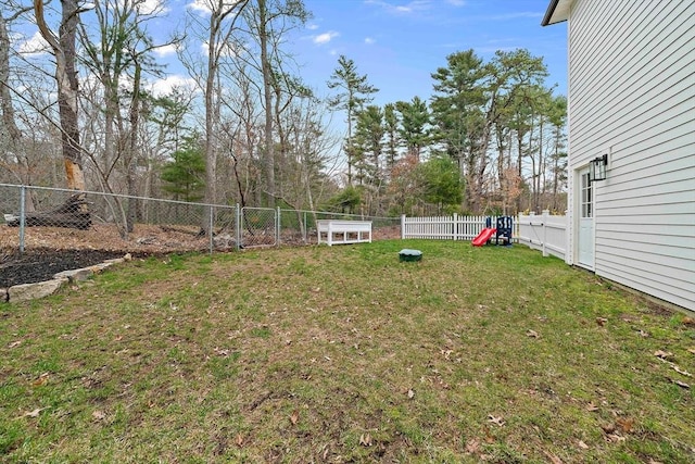 view of yard featuring a fenced backyard and a playground