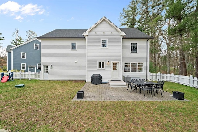 back of property featuring a fenced backyard, a patio, a yard, and central AC
