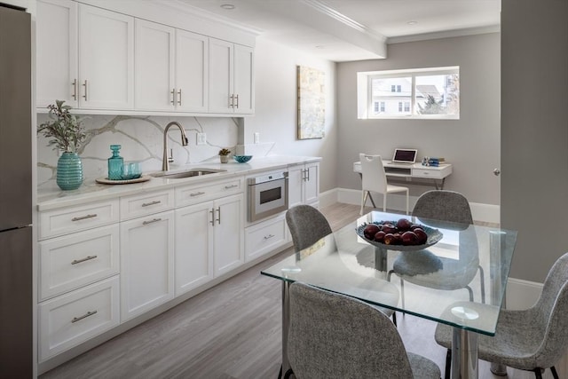 kitchen featuring stainless steel appliances, sink, and white cabinets