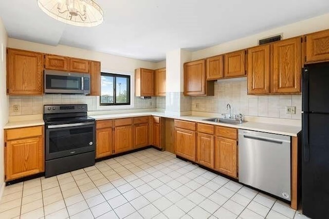 196 Locust Unit 2-508, Lynn, MA 01904 - kitchen featuring black appliances, light countertops, backsplash, and brown cabinets