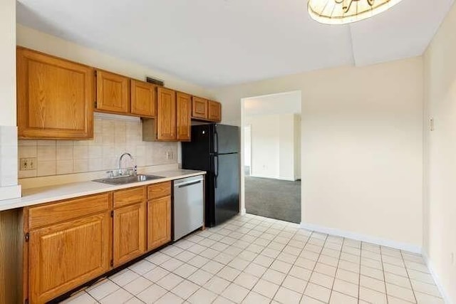 196 Locust Unit 2-508, Lynn, MA 01904 - kitchen featuring stainless steel dishwasher, light countertops, freestanding refrigerator, backsplash, and brown cabinetry