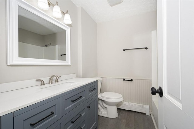 bathroom with vanity, toilet, a textured ceiling, baseboard heating, and wood-type flooring