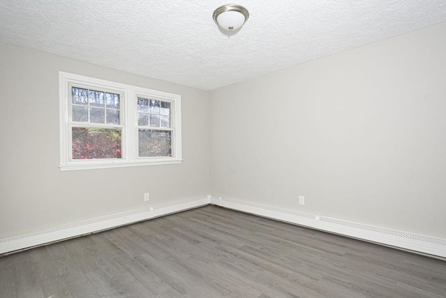 empty room featuring hardwood / wood-style floors, a textured ceiling, and a baseboard radiator