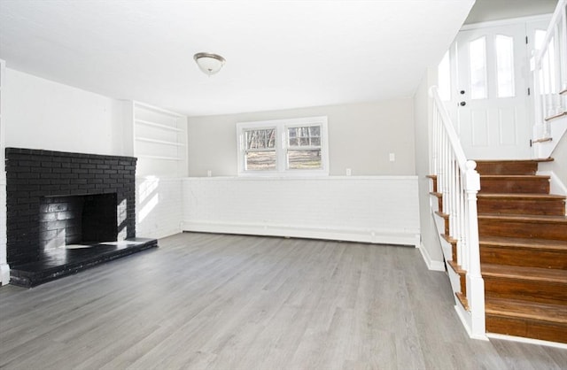 unfurnished living room with a fireplace and light wood-type flooring