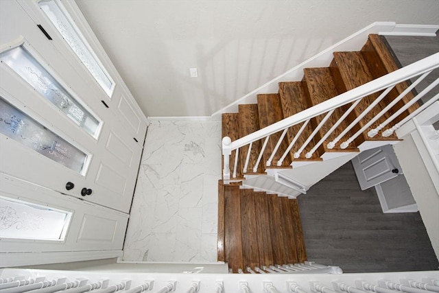 stairs featuring wood walls and a healthy amount of sunlight