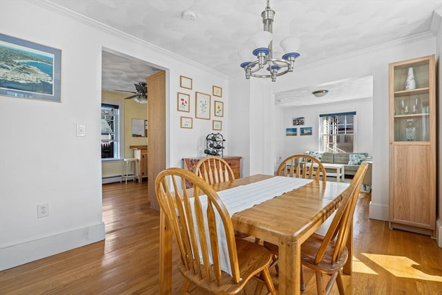 dining area with crown molding, wood finished floors, and a chandelier