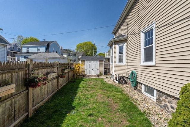view of yard featuring an outdoor structure, a fenced backyard, and a storage unit