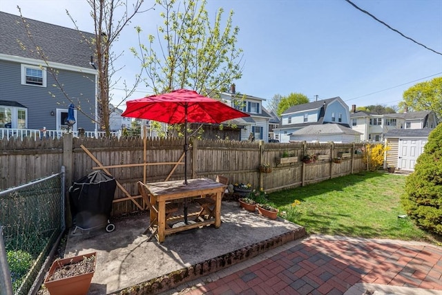 view of patio / terrace with a fenced backyard, an outbuilding, a shed, and a residential view